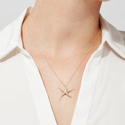 A woman in a white collared blouse showcases the DOro 14K Yellow Gold Diamond Starfish Pendant, 0.51 TCW. The image focuses on her neck and upper chest, highlighting the pendant’s sparkling diamonds.