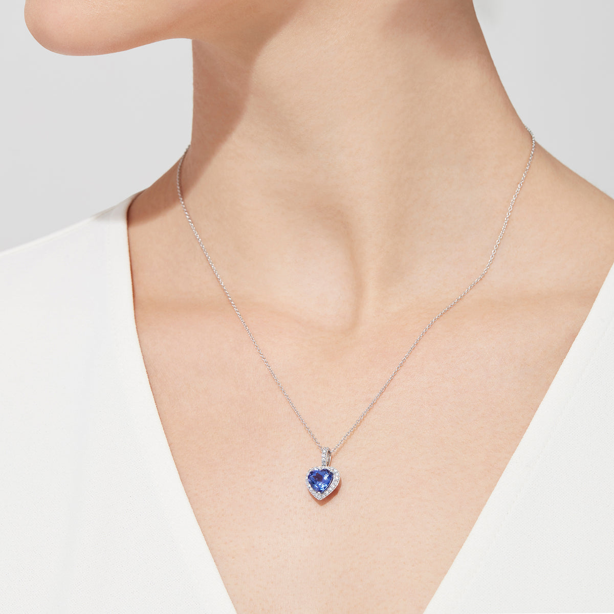 The Nahla Siri 14K White Gold Tanzanite and Diamond Heart Pendant, 2.32 TCW, features a heart-shaped blue tanzanite surrounded by sparkling diamonds, shown on a white background.