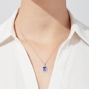 The Nahla Siri 14K White Gold Tanzanite and Diamond Pendant, 1.56 TCW, features a rectangular tanzanite surrounded by sparkling diamonds, elegantly displayed against a white background.