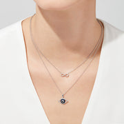 The Novelty 14K White Gold Sapphire & Diamond Evil Eye Pendant (0.42 TCW) features blue sapphires and diamonds in a striking, stylized concentric circle design.