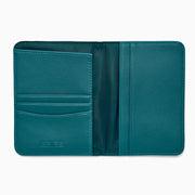 Teal Vegan Leather Passport Holder open to display card slots on the left, a transparent ID section in the center, and a larger pocket on the right, all crafted from vegan leather against a white background.