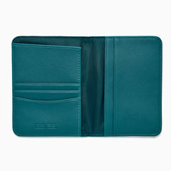 Teal Vegan Leather Passport Holder open to display card slots on the left, a transparent ID section in the center, and a larger pocket on the right, all crafted from vegan leather against a white background.