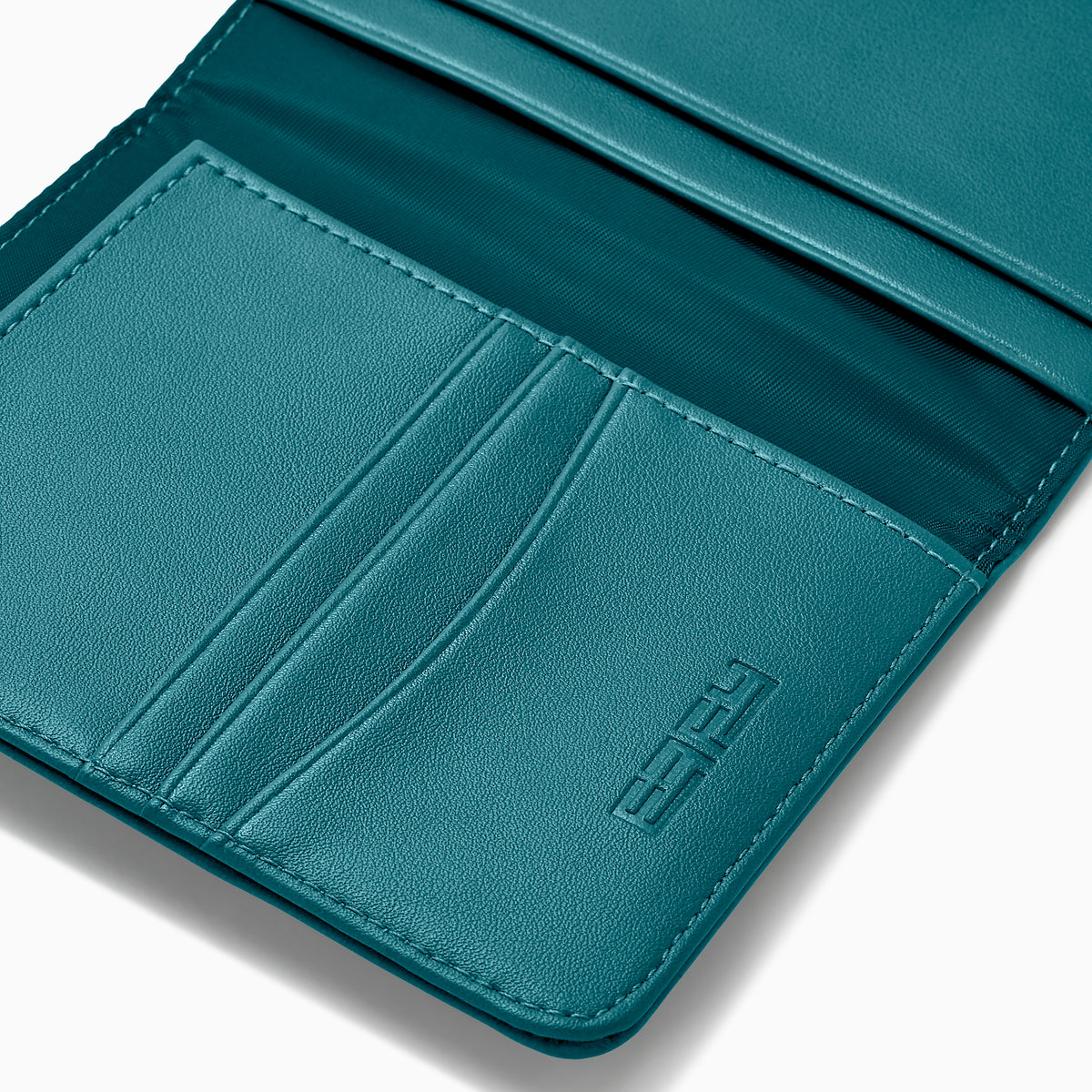 Teal Vegan Leather Passport Holder open to display card slots on the left, a transparent ID section in the center, and a larger pocket on the right, all crafted from vegan leather against a white background.