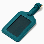 A teal Vegan Leather Luggage Tag with a rectangular clear window and an adjustable strap with gold buckle, shown on a white background.