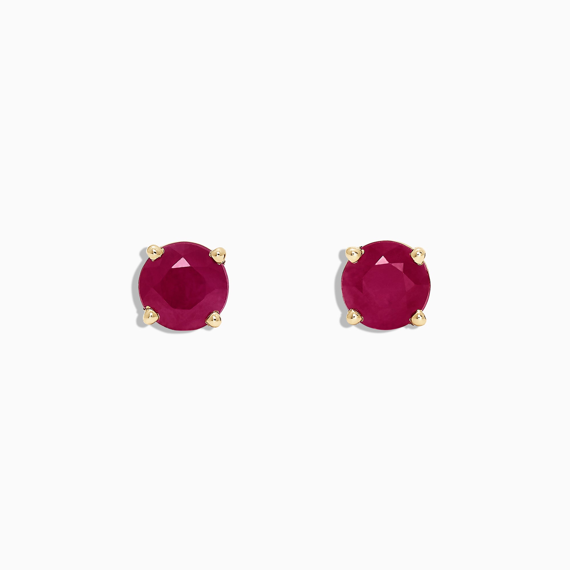 The Ruby Royale 14K Yellow Gold Round Solitaire Ruby Stud Earrings (1.14 TCW) feature faceted rubies in classic four-prong yellow gold settings, showcased on a plain white background.