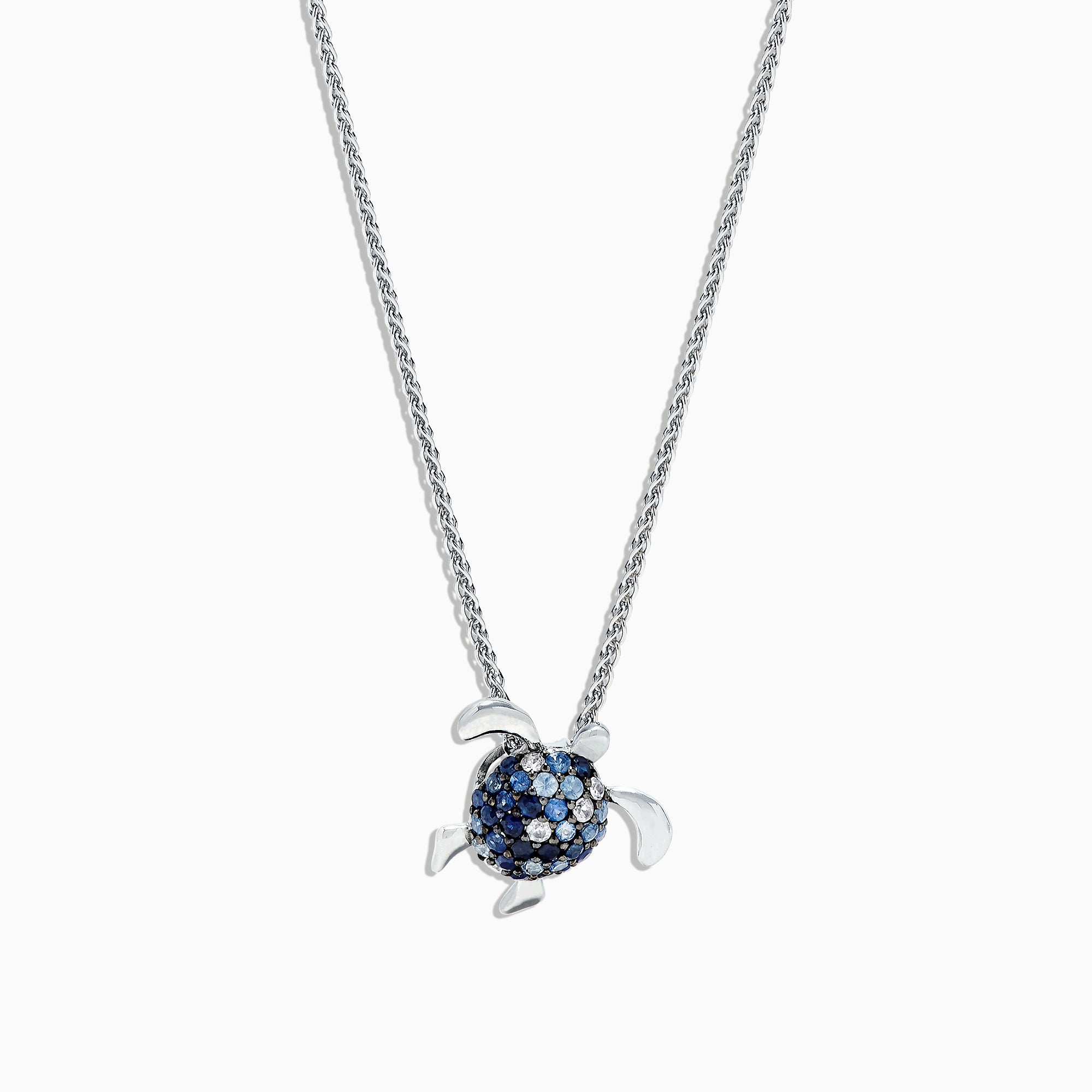 The 925 Sterling Silver Sapphire Splash Turtle Pendant (1.00 TCW) features blue and white gemstones on its shell and is shown against a white background.