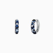 The 925 Sterling Silver Blue Sapphire Splash 1/2 Hoop Earrings, 1.77 TCW, feature alternating rows of blue sapphire and white gemstones and are shown on a plain white background.