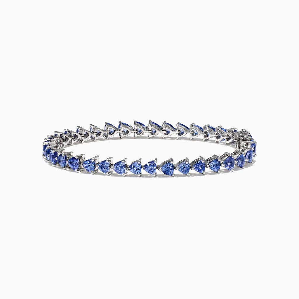 The Nahla Siri Sterling Silver Tanzanite Bracelet, 7.45 TCW, showcases blue triangular gemstones set in prongs and evenly spaced around the band, beautifully displayed against a white background.