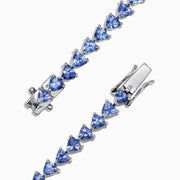 The Nahla Siri Sterling Silver Tanzanite Bracelet, 7.45 TCW, showcases blue triangular gemstones set in prongs and evenly spaced around the band, beautifully displayed against a white background.