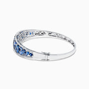 The 14K White Gold Natural Blue Sapphire & Diamond Bangle (7.82 TCW) features an intricate lattice design with clusters of round blue sapphires and sparkling diamonds along the front.
