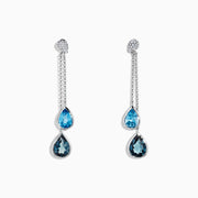 The Ocean Bleu 14K White Gold Blue Topaz and Diamond Earrings (4.28 TCW) feature elegant blue topaz teardrops, delicate chains, and round diamond accents, inspired by classic diamond earring designs.