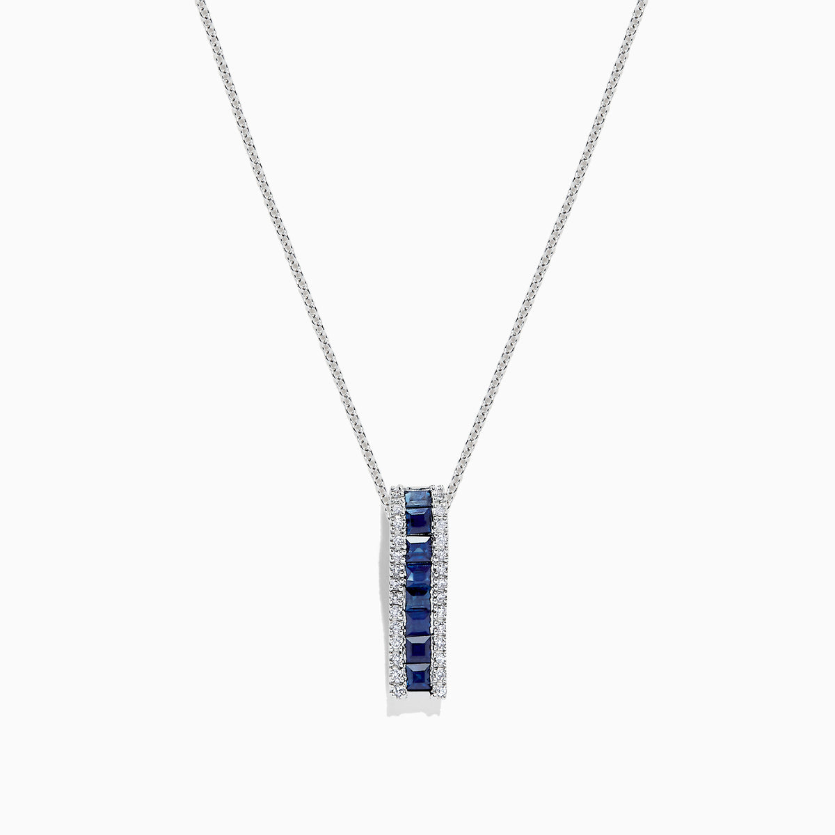 The 14K White Gold Blue Sapphire and Diamond Pendant (1.20 TCW) features a vertical design with square-cut blue sapphires at the center, bordered by sparkling diamonds.