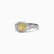 The Canare 18K Two-Tone Gold Cushion Double Halo Yellow Diamond Ring, 0.96 TCW, features a cushion-cut yellow diamond with a double white diamond halo and diamonds set along the band.