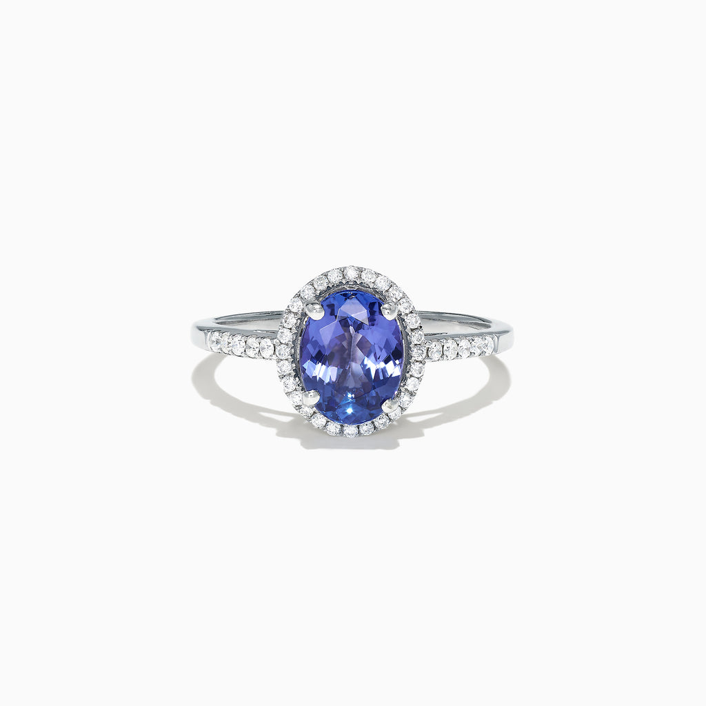 The 14K White Gold Tanzanite and Diamond Ring, 2.24 TCW, features an oval blue tanzanite center with a halo of clear diamonds and diamond-accented band, displayed on a white background.