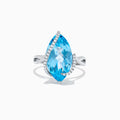 The Ocean Bleu 14K White Gold Blue Topaz & Diamond Ring (7.27 TCW) features a large marquise blue topaz center, curved row of white diamonds on one side, and an elegant looping band design.