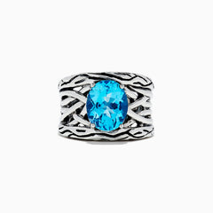 The 925 Lagoon Sterling Silver Blue Topaz Ring, 5.70 TCW features a wide band with a textured wavy design and a large oval blue topaz centerpiece—an elegant statement piece.