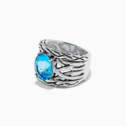 The 925 Lagoon Sterling Silver Blue Topaz Ring, 5.70 TCW features a wide band with a textured wavy design and a large oval blue topaz centerpiece—an elegant statement piece.