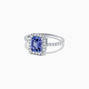 The Nahla Siri 14K White Gold Tanzanite and Diamond Ring, 1.60 TCW, showcases an emerald-cut tanzanite center framed by a halo of diamonds and additional diamonds along the band.
