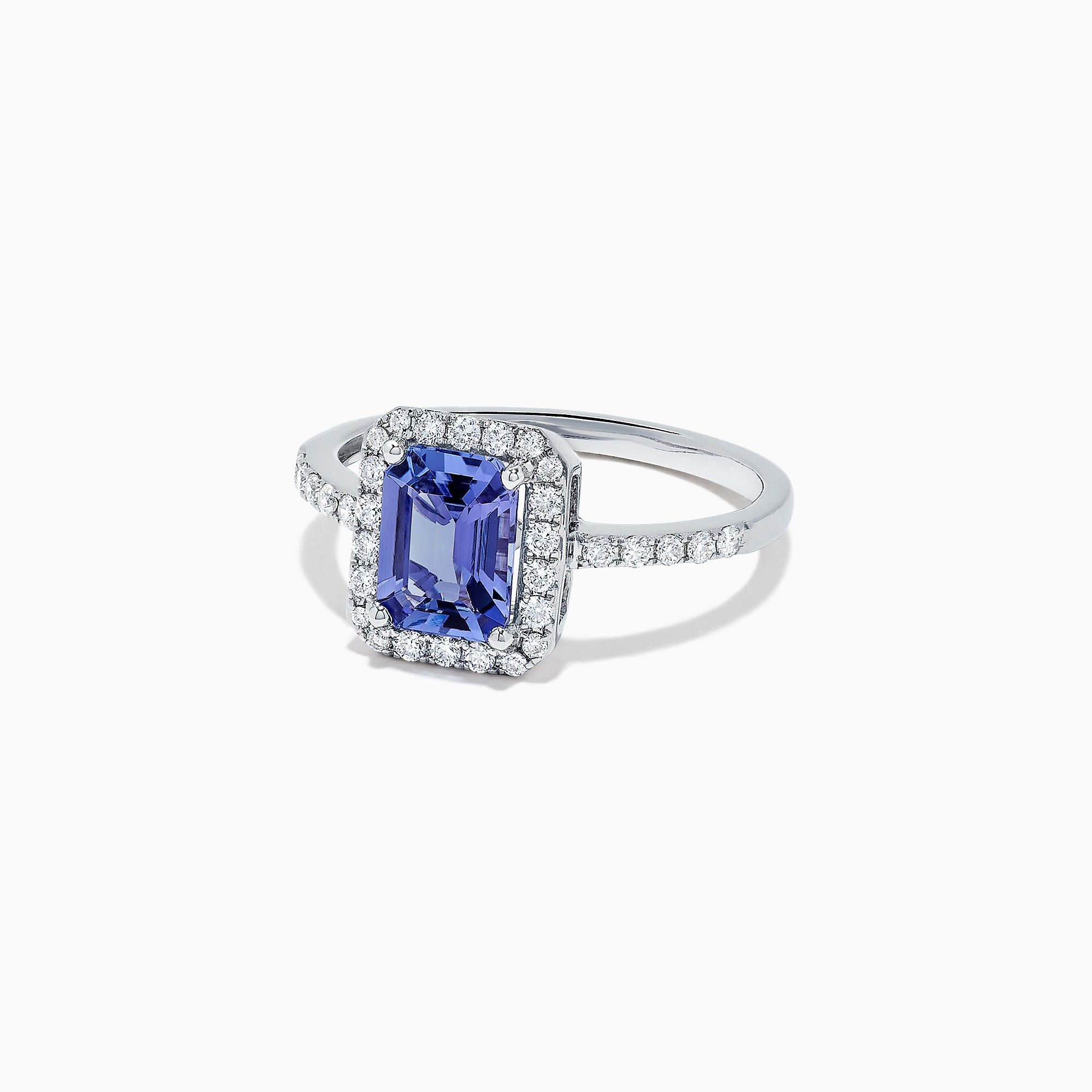The Nahla Siri 14K White Gold Tanzanite and Diamond Ring, 1.60 TCW, showcases an emerald-cut tanzanite center framed by a halo of diamonds and additional diamonds along the band.