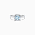 The Aquarius 14K White Gold Aquamarine and Diamond Ring, 0.78 TCW, features a cushion-cut aquamarine center with a diamond halo, shown on a white background.