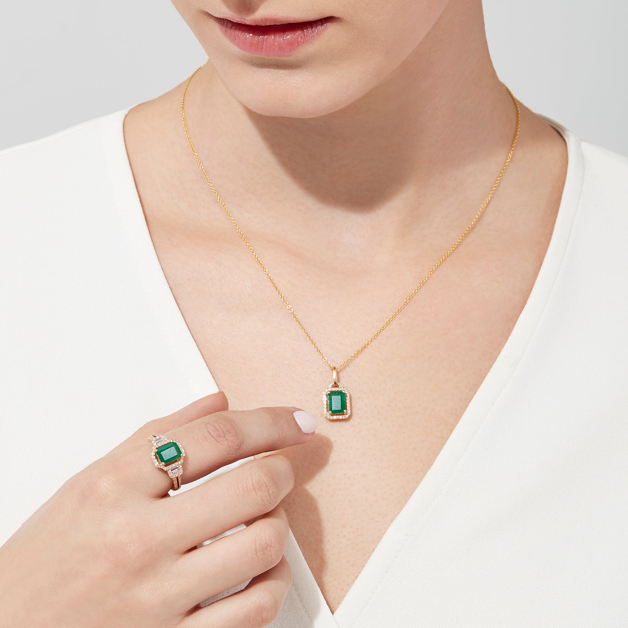 The Brasilica 14K Yellow Gold Emerald & Diamond Pendant, 1.62 TWC, features a rectangular emerald framed by sparkling diamonds on a gold chain, shown against a white background.