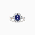 The Nahla Siri 14K Two Tone Gold Emerald Cut Tanzanite and Diamond Ring, 2.32 TCW, showcases a halo of round white diamonds on a diamond-encrusted band, set against a white background.