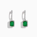 The 14K White Gold Emerald and Diamond Drop Earrings, 2.30 TCW, feature emerald-cut green emeralds surrounded by diamonds and suspended from diamond-studded drops, shown on a white background.
