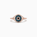 The Novelty 14K Gold Blue, White and Black Diamond Evil Eye Ring (0.37 TCW) features an eye-shaped design with blue, white, and black diamonds arranged in concentric circles and outlined by sparkling white stones.