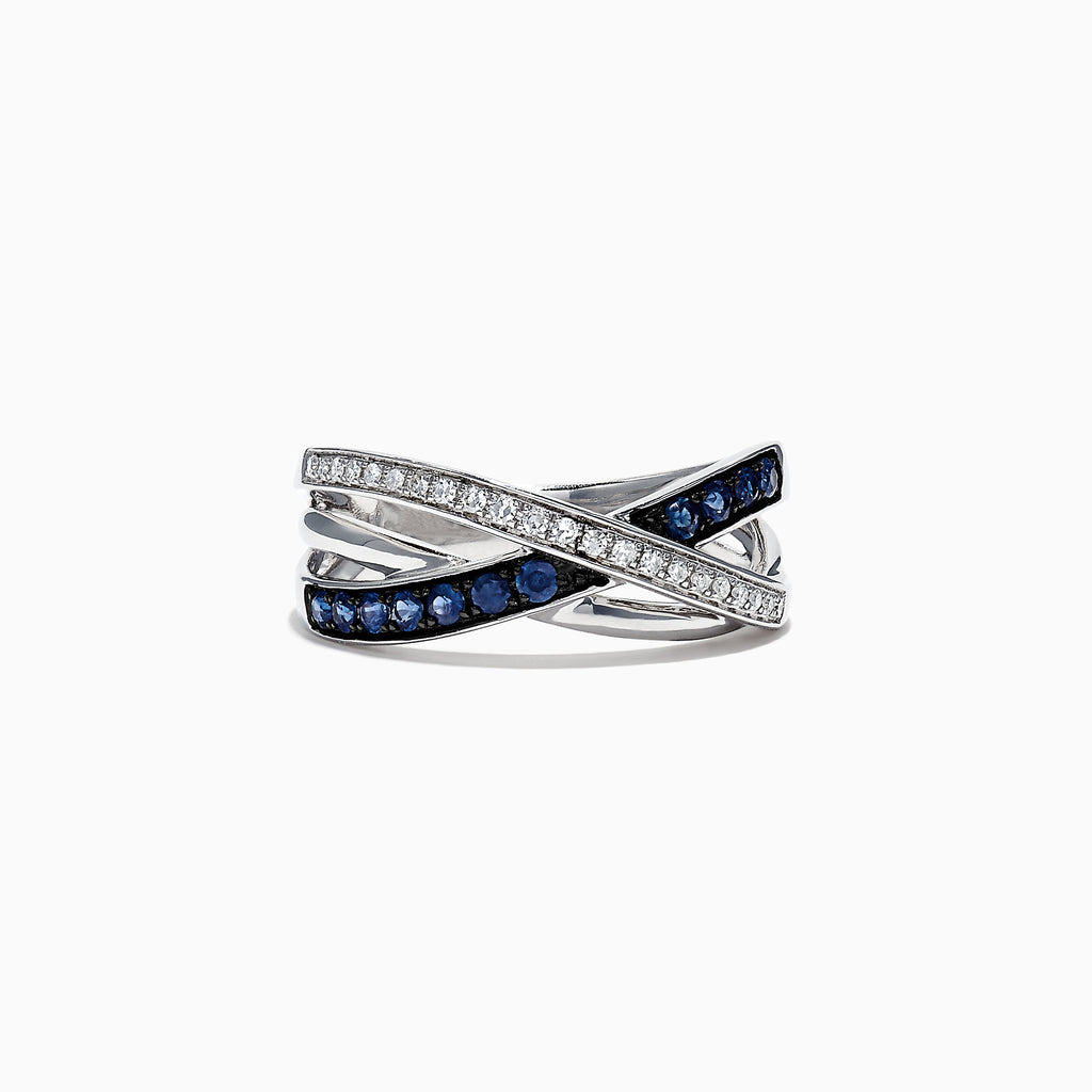 The Royale Bleu 14K White Gold Blue Sapphire and Diamond Ring, 0.39 TCW, showcases an elegant crisscross design with a row of sparkling white diamonds and deep blue sapphires set in overlapping bands.