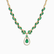 The Brasilica 14K Yellow Gold Emerald and Diamond Necklace, 9.74 TCW, features oval emeralds accented with diamonds and a central teardrop-shaped emerald pendant surrounded by a sparkling diamond halo.
