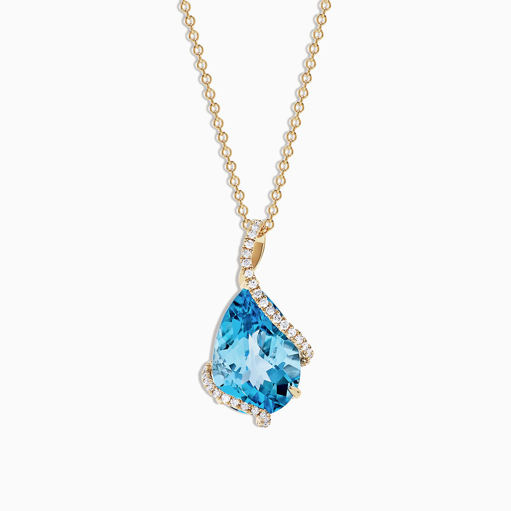 The Ocean Bleu 14K Yellow Gold Pendant features a 6.09 TCW blue topaz framed by sparkling diamonds in an asymmetrical design on a yellow gold chain, set against a white background.