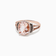 The 14K Rose Gold Morganite and Diamond Ring, 3.42 TCW, showcases a striking oval morganite center stone encircled by a double halo of white and black diamonds, with additional sparkling diamonds on the split shank.