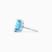 The Ocean Bleu 14K White Gold Blue Topaz and Diamond Ring, 8.06 TCW, showcases a large rectangular blue topaz center with sparkling diamonds along the band, displayed on a plain white background.