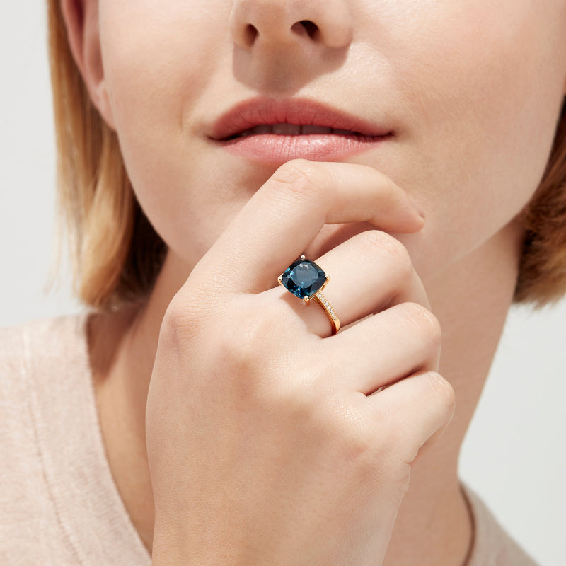 The Ocean Bleu 14K yellow gold ring boasts a cushion-cut London Blue Topaz centerpiece and sparkling round diamonds along the band, totaling 4.54 TCW.