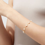 The 14K Yellow Gold Cultured Fresh Water Pearl Station Bracelet features evenly spaced pearls on a delicate gold chain with a small round clasp, shown against a white background.