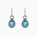 A pair of 925 sterling silver and 18K yellow gold earrings with blue topaz gemstones, 4.56 TCW, shown on a white background.
