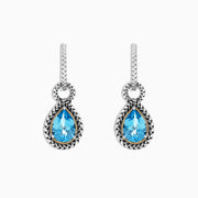 A pair of 925 sterling silver and 18K yellow gold earrings with blue topaz gemstones, 4.56 TCW, shown on a white background.