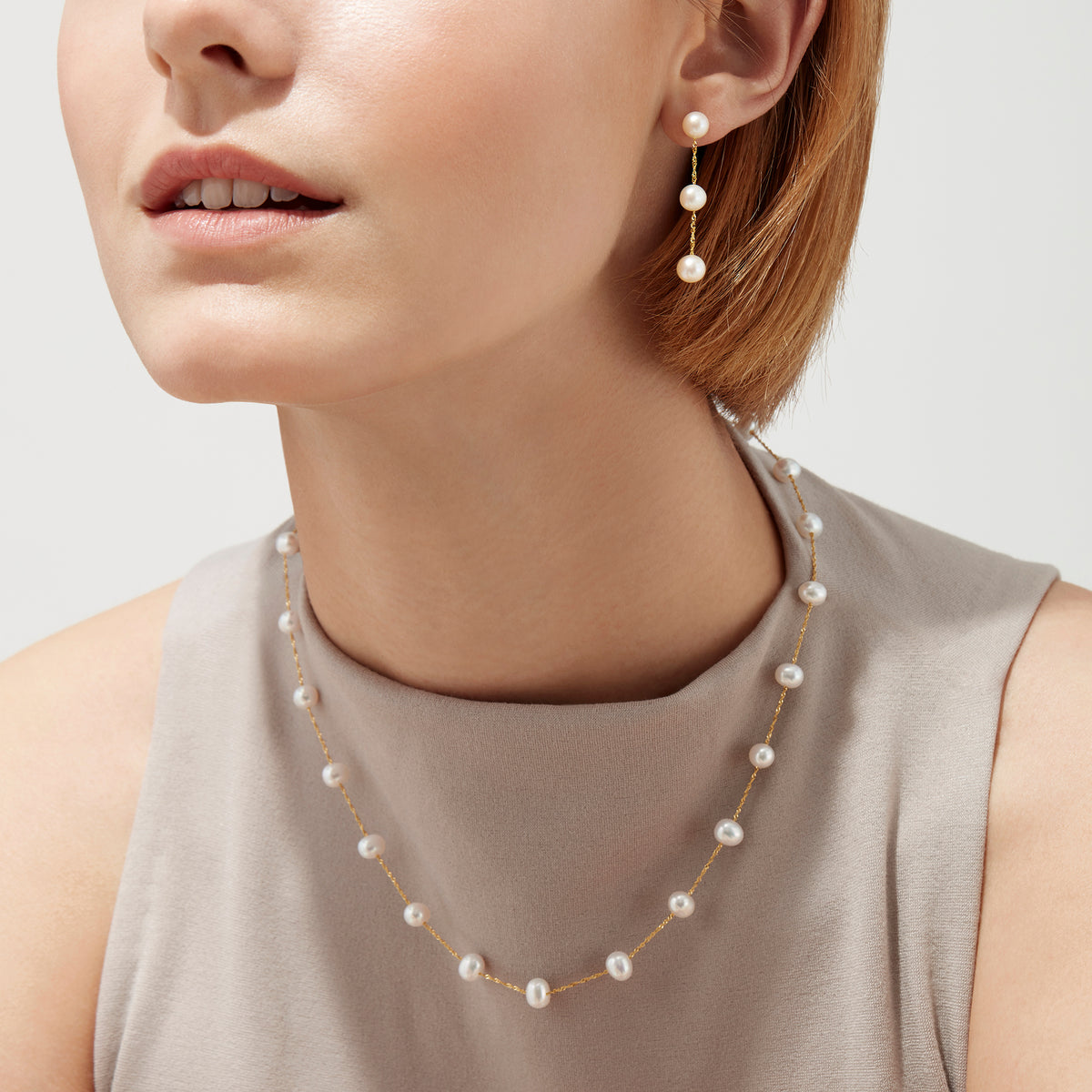 The 14K Yellow Gold Fresh Water Cultured Pearl 18 Necklace features evenly spaced round pearls with subtle variations, creating a simple, elegant look. Pearls are set on a delicate yellow gold chain and displayed against a plain white background.