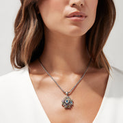 A 925 silver chain necklace featuring a cross-shaped pendant adorned with vibrant multi gemstones, totaling 4.09 TCW, arranged in a strikingly symmetrical design.
