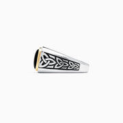 The Mens Sterling Silver and 14K Yellow Gold Onyx Ring, 3.40 TCW features a rectangular black onyx stone in a yellow gold bezel with detailed Celtic knot designs on the sides.