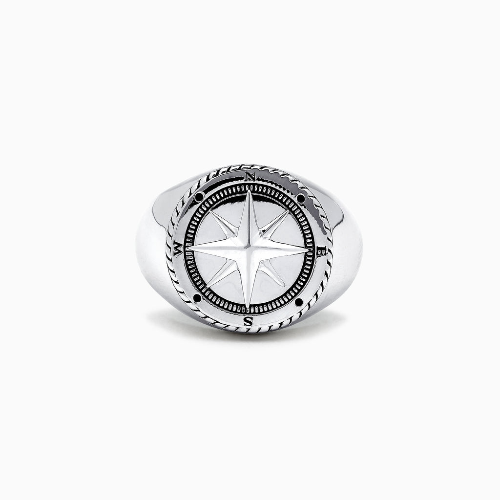 The Mens Sterling Silver Compass Ring showcases a detailed star at the center and engraved directional markers (N, E, S, W) around the edge. Its striking design is highlighted against a plain white background.