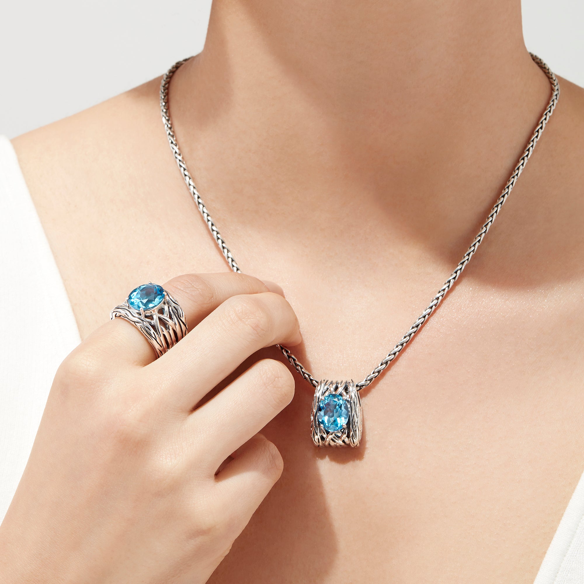 The 925 Lagoon Sterling Silver Blue Topaz Ring, 5.70 TCW features a wide band with a textured wavy design and a large oval blue topaz centerpiece—an elegant statement piece.