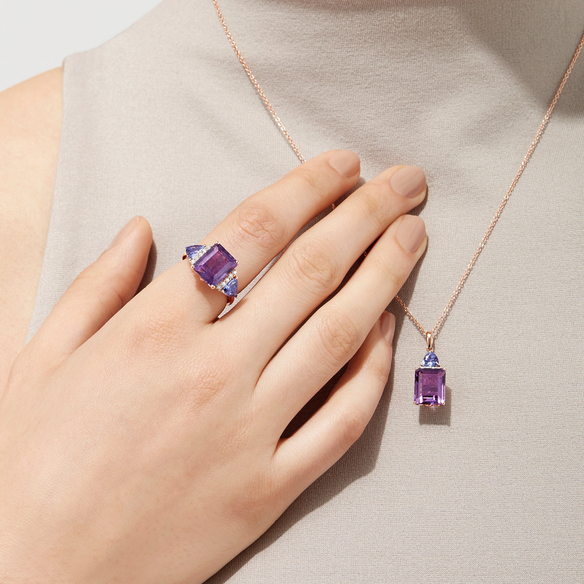 The 14K Rose Gold Amethyst, Tanzanite and Diamond Ring (7.49 TCW) showcases a large rectangular amethyst center, two triangular tanzanites, and four round diamonds on each side, all set against a white background.