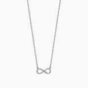 The Novelty 14K White Gold Diamond Infinity Necklace features a delicate infinity symbol pendant with 0.09 TCW diamonds, centered on a fine chain against a white background.
