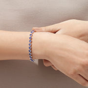 The Nahla Siri Sterling Silver Tanzanite Tennis Bracelet, 11.40 TCW, features a circle of evenly spaced triangular tanzanite gemstones and is finished with a secure clasp.