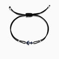 The Novelty 14K White Gold Sapphire Anchor String Bracelet, 0.15 TCW, features a black adjustable cord and a white gold anchor charm accented with sapphires, shown on a white background.