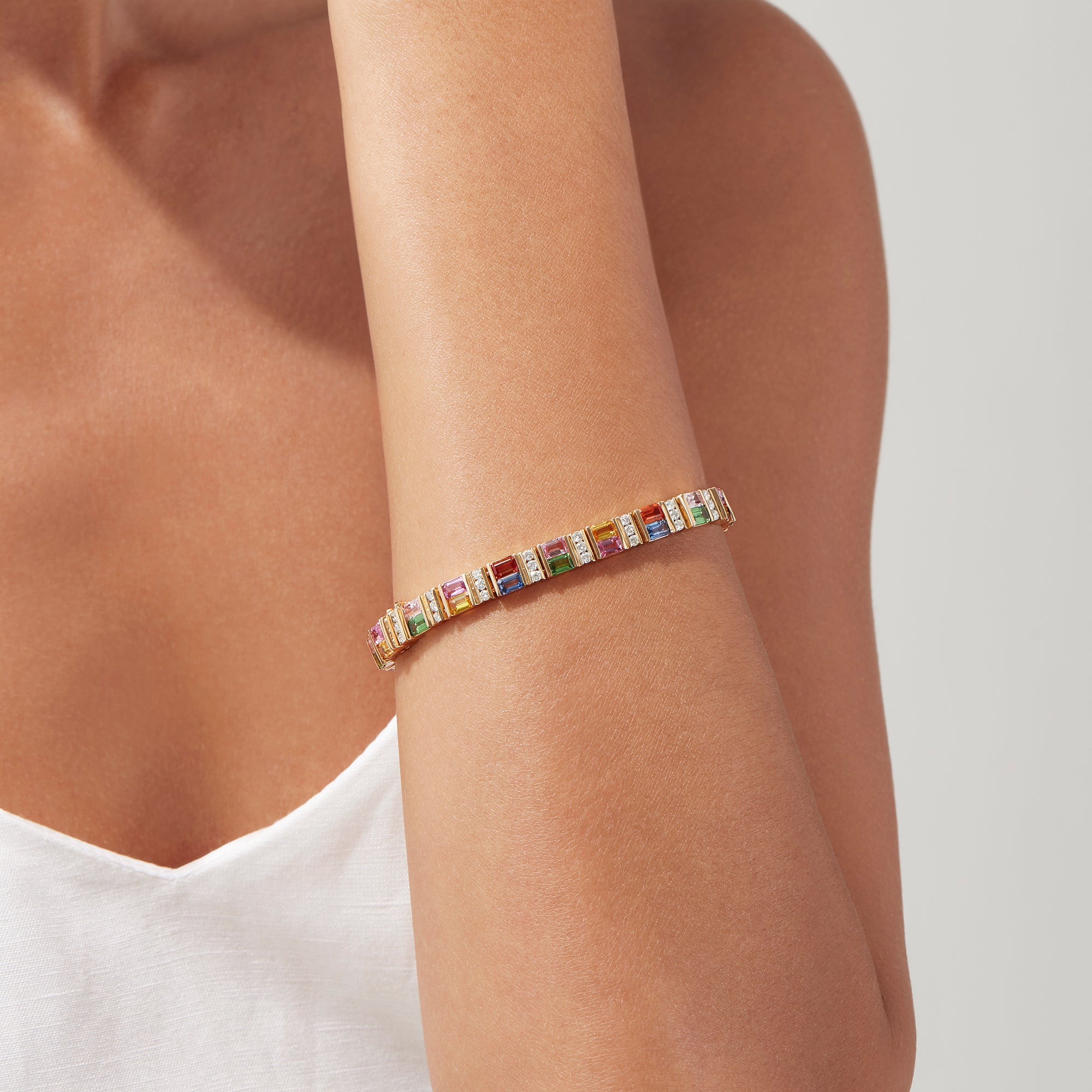 The Watercolors 14K Gold Multi Sapphire and Diamond Bracelet, 16.10 TCW, features rectangular blue, pink, green, yellow, and orange sapphires set in a repeating pattern along its length.