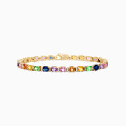 The Watercolors 14K Gold Multi Sapphire and Diamond Bracelet, 8.96 TCW, showcases a vibrant row of round blue, purple, pink, orange, yellow, and green sapphires sparkling on the gold band against a white background.