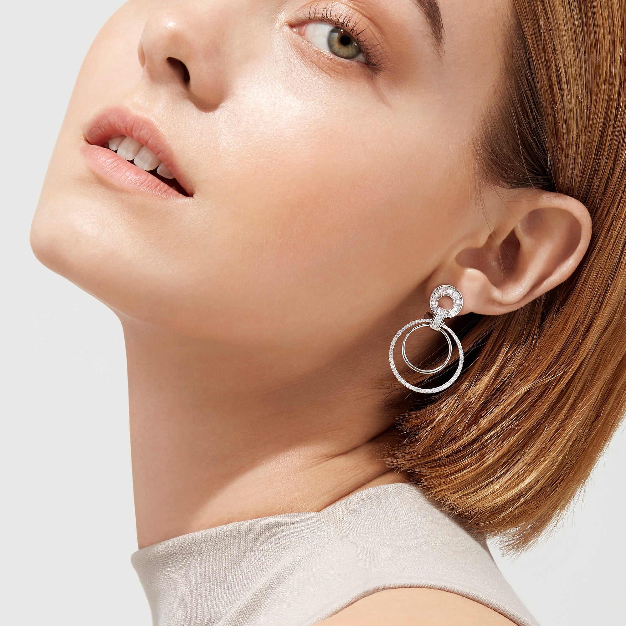The Classique 14K White Gold Diamond Drop Earrings, 1.12 TCW, showcase two interlocking circles— the larger ones adorned with sparkling diamonds— presented against a plain white background.