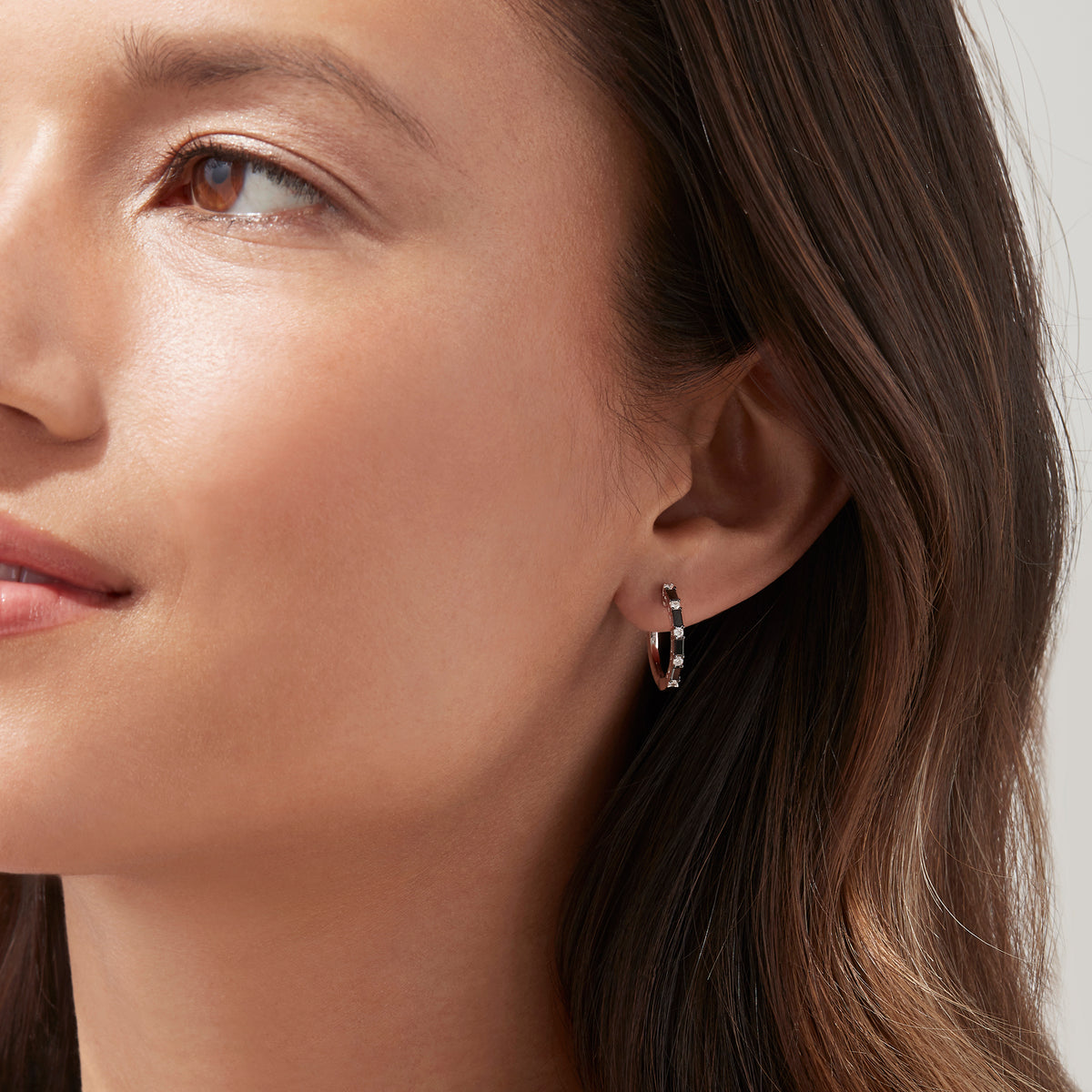 A pair of 14K white gold hoop earrings with black and white diamonds totaling 0.45 TCW, showcased against a plain white background. Effy craftsmanship enhances the modern elegance of this striking jewelry piece.